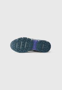 Trail running shoe outsole in dark teal with a zigzag tread pattern. Features a purple accent near the center. Textured for grip.