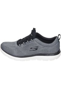 Lättvikts sportskor i mörkgrått med en texturerad mesh-ovandel, svarta accenter och vit sula. Har snörning och logodetaljer på sidan.