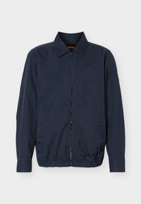 Ανδρικό ελαφρύ μπουφάν σε ναυτικό μπλε χρώμα με φερμουάρ, γιακά, μακριά μανίκια, δύο πλαϊνές τσέπες και ελαστικό τελείωμα.