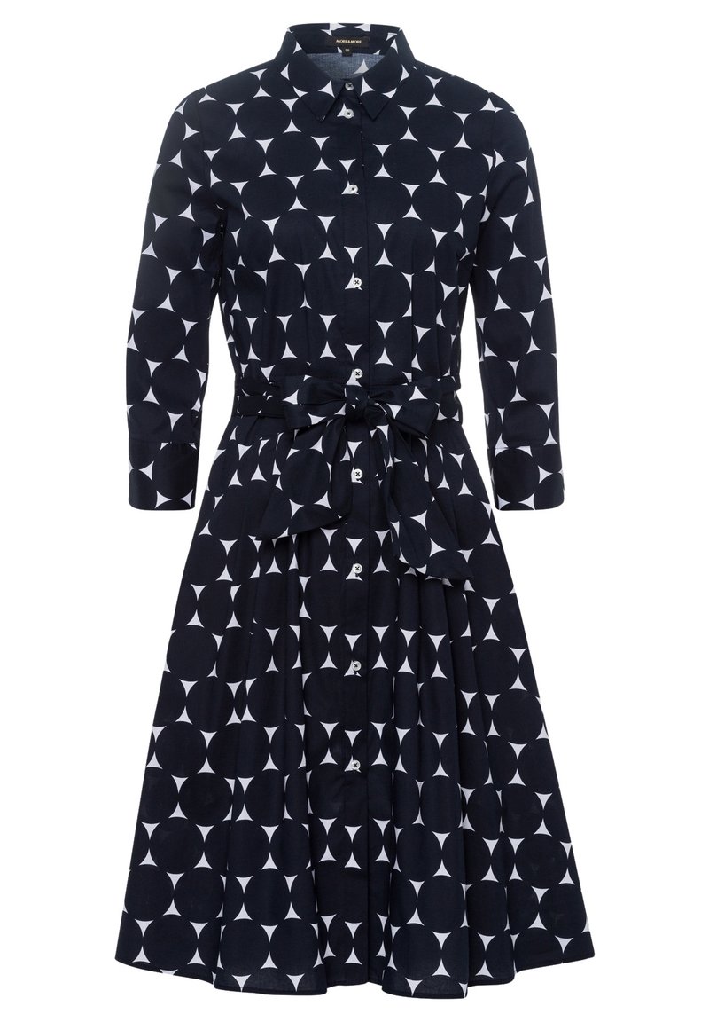 Vestido azul marino con un patrón geométrico blanco, que presenta un escote con collar, mangas largas, una cintura ceñida con cinturón y una falda con plisados.