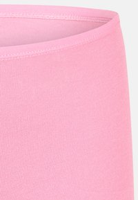 Gros plan sur une ceinture en tissu côtelé rose avec une double couture soignée le long du bord supérieur.