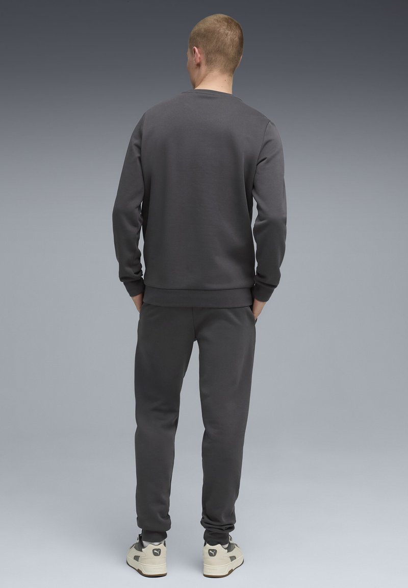 Dunkelgrauer Pullover und passende Jogginghosen aus einem weichen, strukturierten Stoff, mit gerippten Bündchen und einem lockeren Schnitt.
