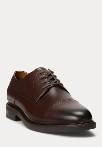 Hnědá kožená kotníková polobotka se zaoblenou špičkou, designem s kapličkou, texturovaným povrchem a vrstveným podpatkem. Má ploché tkaničky a minimální šití.