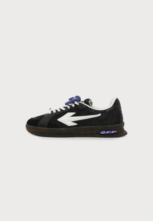 Baskets noires avec un motif de flèche blanche sur le côté, lacets blancs, serrure de lacets violette et semelle noire avec logo bleu "OFF".
