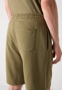 Kaki bomullsshorts med et uformelt design, som har strikk i livet, en baklomme og sidesplitter for ekstra komfort.