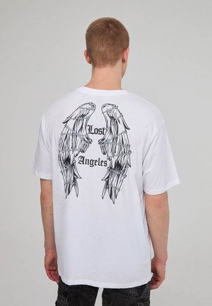 T-shirt bianca in cotone a maniche corte con grandi grafiche di ali nere e testo "Lost Angeles" sul retro. Design semplice con scollatura a girocollo.