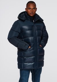 Námořnická modrá péřová bunda s kapucí, s prošívaným designem, zapínáním na zip a postranními kapsami. Hladký, lesklý materiál s uvolněným střihem.