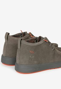 Scarpe alla caviglia in suede grigio con accenti arancioni e suola in gomma testurizzata. Presentano un tacco a loop e un logo ricamato vicino alla caviglia.