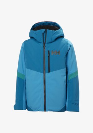 Enfant portant une veste de ski bleue et un pantalon, un casque noir, des lunettes de ski avec verres teintés rouges, et des gants noirs avec le logo de la marque sur la poitrine et les gants.