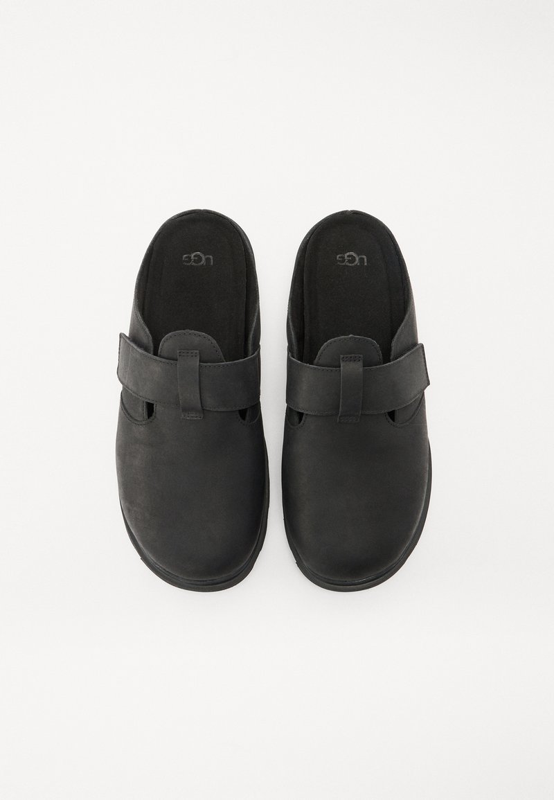 Czarne buty wsuwane z miękkiego zamszu z paskiem na górze. Okrągły nosek i wyprofilowana wkładka dla komfortu. Gładkie, matowe wykończenie.