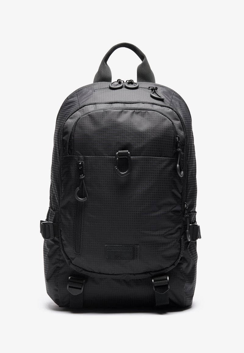 Sac à dos noir en tissu durable avec un motif à carreaux ; il possède plusieurs fermetures éclair, des bretelles réglables et une poignée supérieure pour le transport.