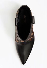 Svart läder sko med spetsig tå och ett leopardmönstrat pälsaccent. Har en slip-on design och en slät yta på det svarta lädret.