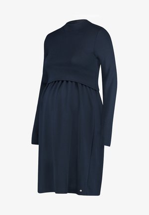 Laivastonsininen äitiysmekko, jossa on pitkät hihat, pyöreä pääntie ja pussitettu vyötärö. Sujuva, joustava kangas; pieni logo yksityiskohtana helmassa.