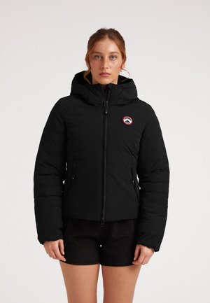 Zwarte pufferjack met een capuchon, voorzien van een frontzipper en twee zijzakken. Inclusief een rond logo op de borst met een bergontwerp.