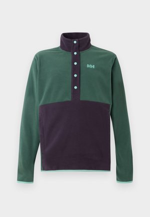 Half-zip fleece pullover in groen en donkerpaars, met een hoge kraag, knoopdetail en een logoaccent op de borst. Zachte textuur.