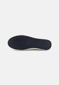 Suela de zapato de goma de color azul oscuro con un patrón geométrico texturizado. Un perímetro de goma blanca contornea la suela. Diseño plano y ovalado.
