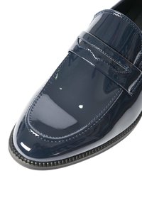 Mocassino in pelle blu navy lucida con punta arrotondata, cuciture visibili e una fascia decorativa sulla parte superiore.