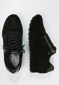 Des baskets noires en daim présentent des détails perforés, une semelle compensée, des zippers latéraux et des lacets noirs contrastants. Fini texturé sur l'ensemble.