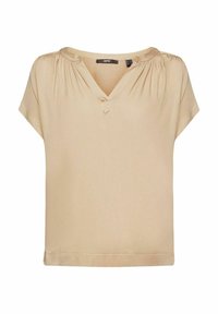 Blouse beige à col en V avec des manches courtes, fabriquée en tissu lisse. Présente un fronces aux épaules et un subtil nœud décoratif au niveau du col.