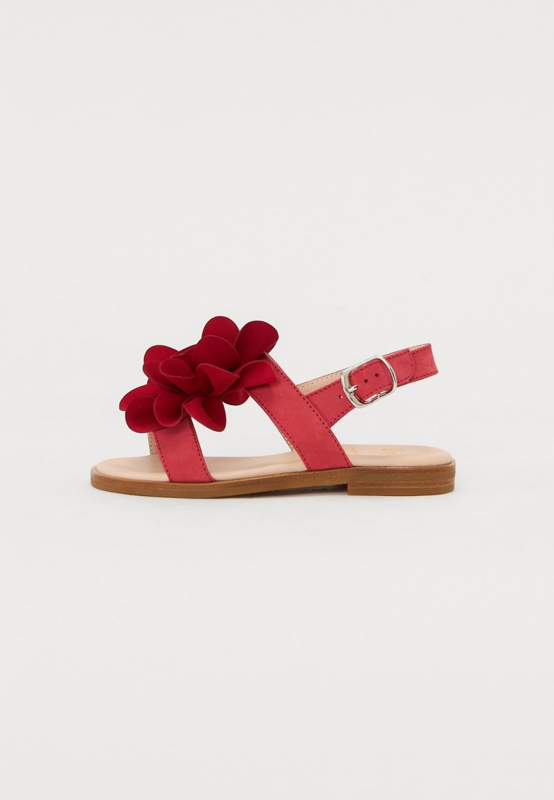 Røde sandaler med blomst detalj, laget av mykt materiale. Har to ankelstropper og en flat tresåle.