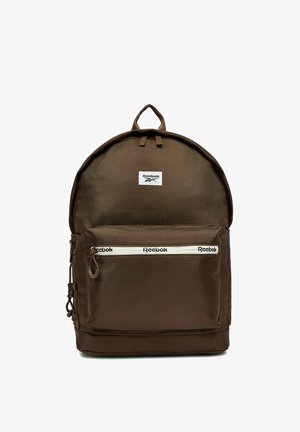 Ciemnobrązowy plecak Reebok z przednią kieszenią na zamek, naszywką z logo na górze oraz pętlą z materiału na górze.