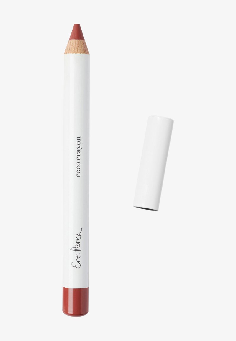 Kleurpotloodvormige lipproduct met een houten punt en een glanzend witte body, met de tekst "Coco Crayon" en "Ere Perez" in een minimalistisch ontwerp.