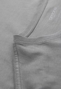 Ljusgrå bomullströja med rund halsringning och synliga sömmar. Slät yta med en subtil glans och utan mönster eller dekorationer.