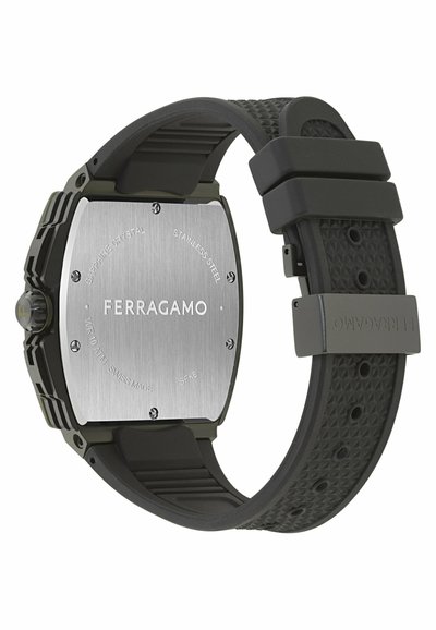 Ferragamo käekella tagakülg roostevabast terasest korpusega, musta tekstuuriga kummirihmaga ja graveeritud kaubamärgiga korpuse ning rihma pandlal.