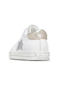 Sneaker bianco con un accento a stella argento testurizzato, un tab sul tallone in metallo dorato e una suola in gomma bianca. Parte superiore in pelle liscia con dettagli minimi.