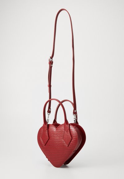 Borsa a forma di cuore rossa con texture in coccodrillo, due manici superiori, tracolla lunga rimovibile e zipper argento su sfondo neutro.
