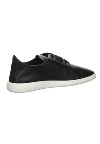 Baskets basses en cuir noir avec lacets noirs et semelle blanche, vues de côté sur fond blanc.