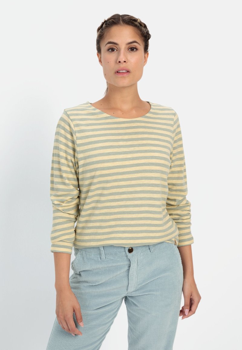 Lichtgroen en crèmekleurig gestreept shirt met lange mouwen en een ronde halslijn, gedragen met lichtblauwe corduroy broek met een gestructureerde afwerking.