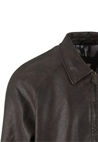 Jachetă maro din piele, cu finisaj texturat, guler și fermoar frontal. Dispune de o căptușeală interioară netedă. Detalii de cusătură vizibile.