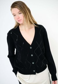 Cardigan nero in tessuto morbido, con scollo a V, chiusura con bottoni e delicato motivo a diamante ricamato in grigio.