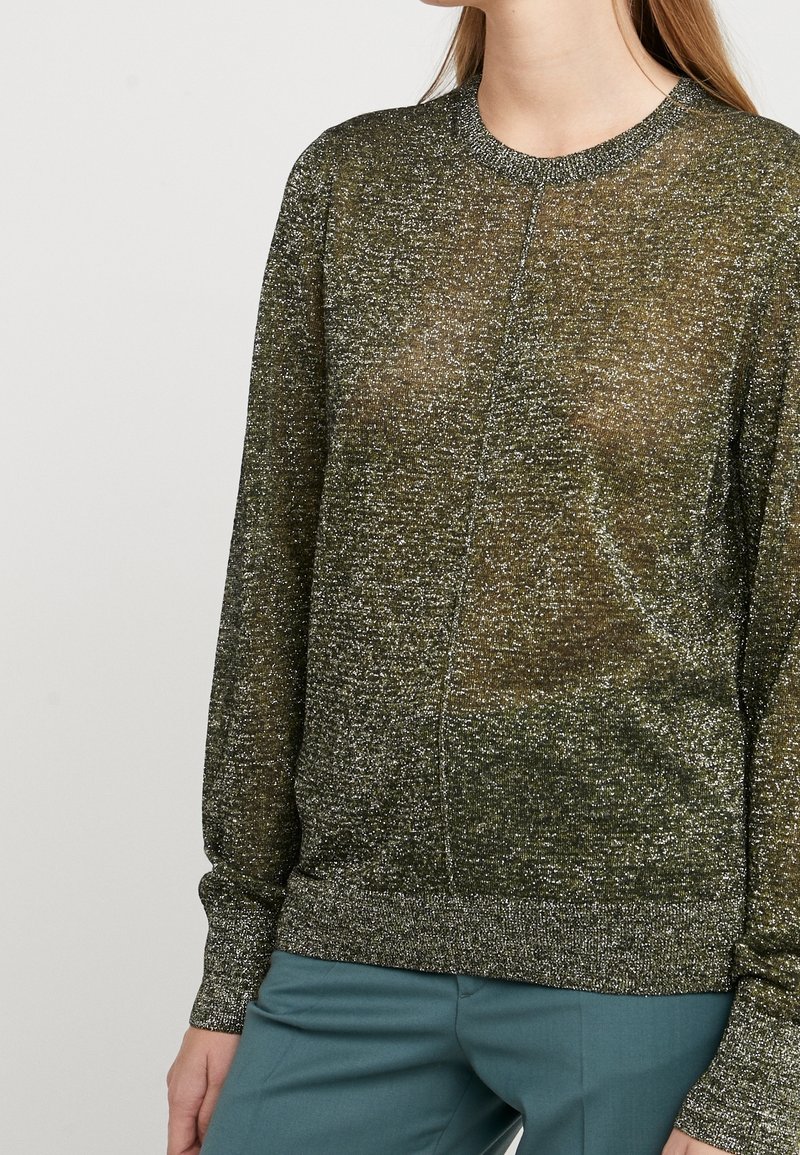Pull vert, transparent avec un subtil éclat, col rond et manches longues. Présente un ourlet et des poignets côtelés. Texture lisse avec une coupe décontractée.