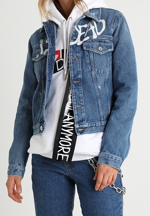 Giubbotto di jeans con dettagli sbiaditi, caratterizzato dalla scritta bianca "DEAD" sul davanti. Abbinato a una felpa bianca con cappuccio e jeans blu. Accenti in metallo argentato.