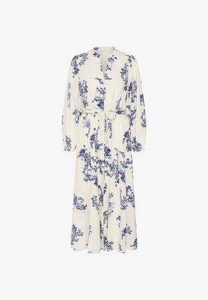 Robe longue blanche avec motifs floraux bleus, manches longues, devant boutonné et ceinture nouée à la taille.