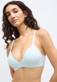 Ανοιχτό μπλε τριγωνικό σουτιέν με λεπτές τιράντες, ριμπ υφή και λαιμόκοψη σε σχήμα V. Διαθέτει διακριτικό λογότυπο στο πλευρό.