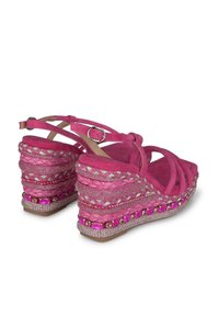 Roze suède wedge sandalen met een kruislingse ontwerp, gevlochten accenten en geplaatste juwelen op de hak. Inclusief verstelbare enkelband.