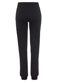 Schwarze Jogginghosen aus weichem Stoff, mit einem elastischen Bund und schmal zulaufenden Beinen mit Bündchen an den Knöcheln. Einfaches, einfarbiges Design.