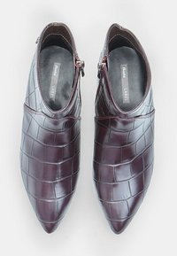 Burgundy leather ankle boots with a pointed toe, featuring a crocodile texture and side zippers for easy wear. Smooth interior lining.
