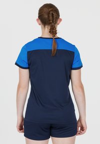 Marinblå idrottströja med korta ärmar, med en blå överdel. Slät tyg med en avslappnad passform, i kombination med matching shorts.