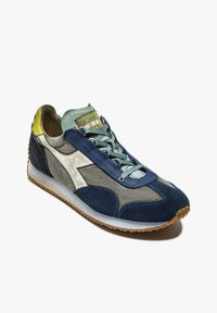 Zapatillas de gamuza azul marino y gris con un collar texturizado en menta, acentos de malla y una suela de goma ligera. Presenta un logo blanco en el lateral.