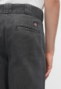 Ciemnoszare spodnie z tkanym wzorem, standardowym paskiem w talii i tylną kieszenią z kolorową łatą logo Dickies.