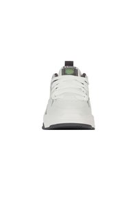 Bílé tenisky s šedými akcenty, s kulatou špičkou, plochými tkaničkami a texturovanou podrážkou. Značka je uvedena na jazyku a patě.