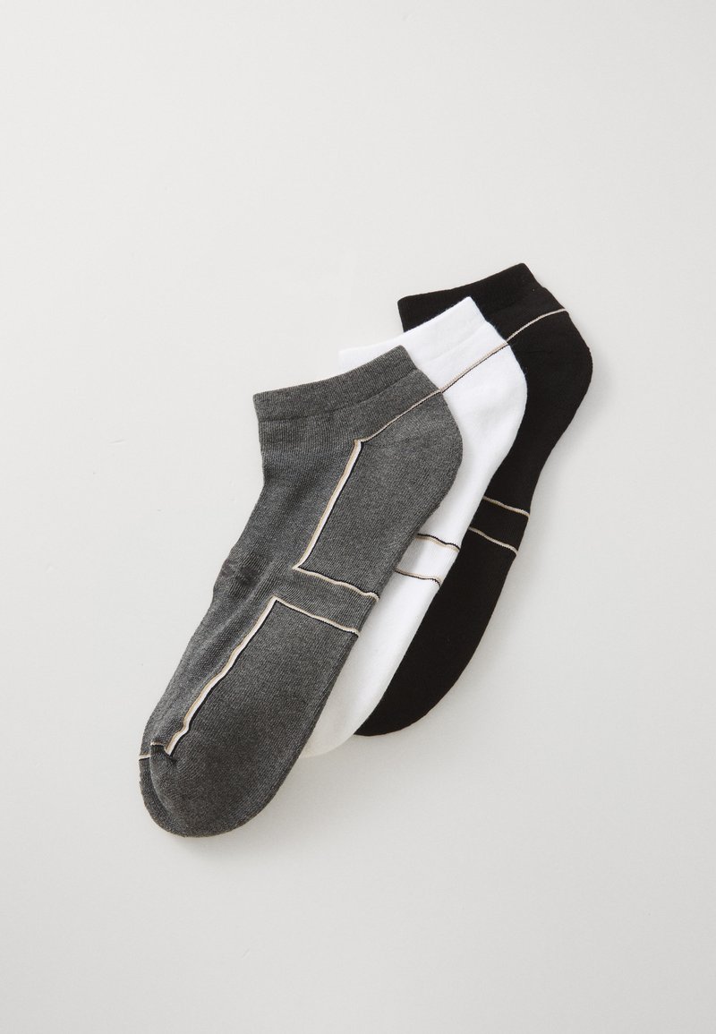 Drei Paar niedrige Socken in Schwarz, Weiß und Dunkelgrau, mit kontrastierenden Nähten entlang der Kanten.