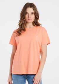 Korte mouw T-shirt in lichtoranje katoen met een relaxte pasvorm. Heeft een kleine witte palmboom grafiek op de borst.