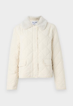 Cream-colored quilted jacket with a faux fur collar, snap buttons, and two front pockets. Soft texture and cropped design.