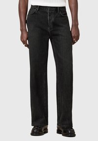 Schwarze Jeans aus Denim mit geradem Schnitt, mittelhoher Taille und klassischem Fünf-Taschen-Design. Verfügt über subtile Textur- und Nahtdetails.