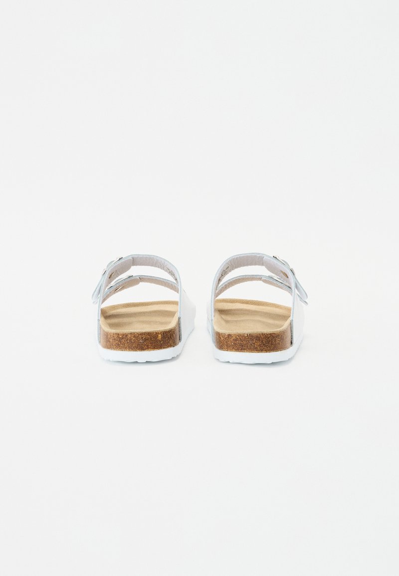 Sandales blanches avec deux sangles ajustables, semelle en liège et semelle légère et texturée. Design simple avec des sangles lisses et un dos uni.